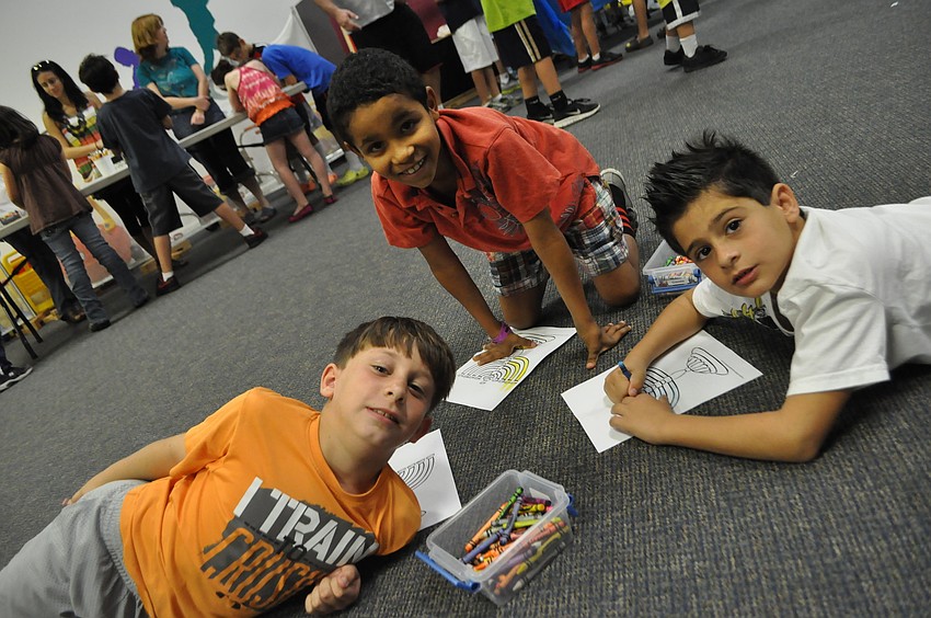 Isaiah Cohen, Jordan Gorn and Marc Ash color dradles at the Hanukah celebration.