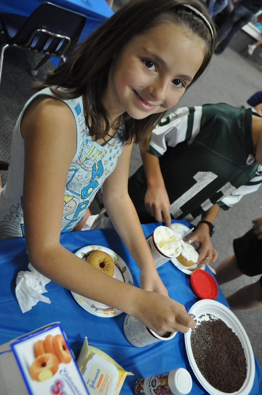 Jordan Cohen puts chocolate sprinkles on her donut.