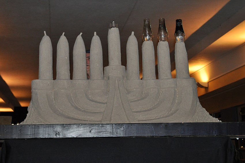 As part of the ceremony, a sand menorah was lit.