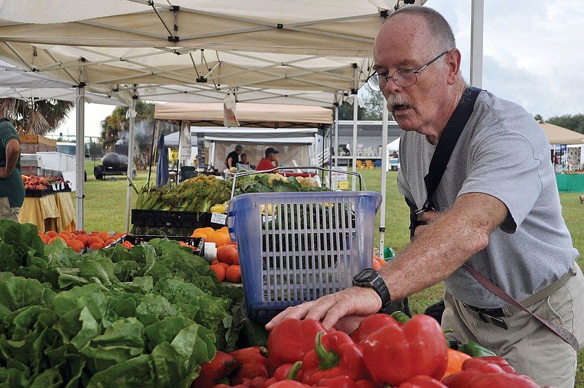 Kevin McDonnell shops for produce from Brownâ€™s Grove, Oct. 3, at the opening day of the Phillippi Farmhouse Market.