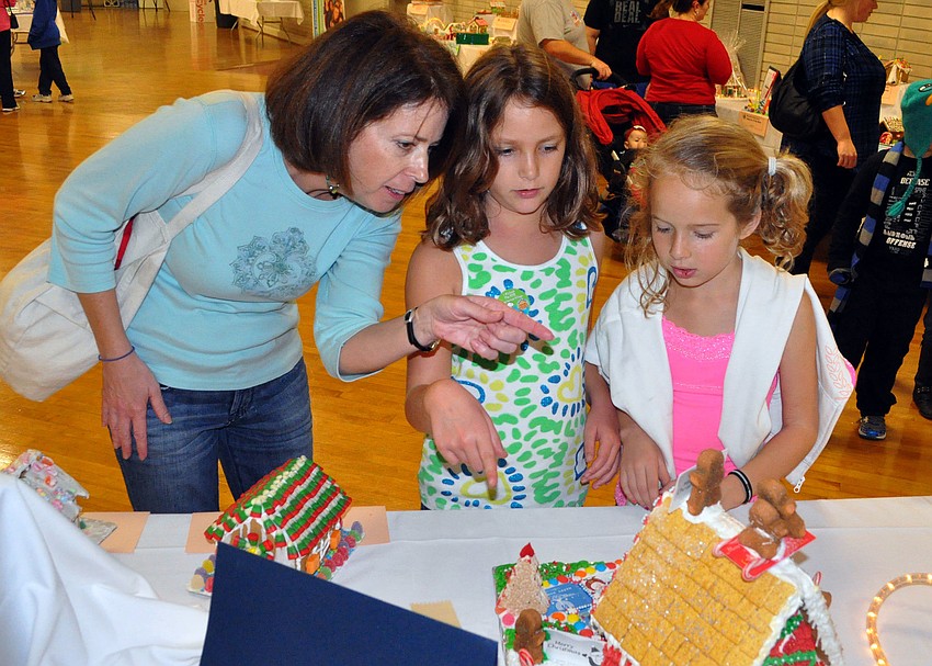 Gwyn Baker looks at gingerbread houses with her daughter Rachel, 9, and her daughterâ€™s friend, Brielle Campbell, 8.