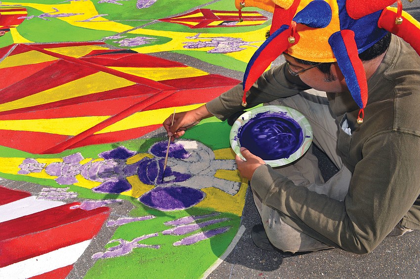 Anthony Cappetto wore a jester hat while working on his piece, â€œHigh Wire,â€ on Pineapple Avenue during the fifth annual Chalk Festival. Nik Wallenda walked across Cappettoâ€™s painted high wire during the Chalk Festival.