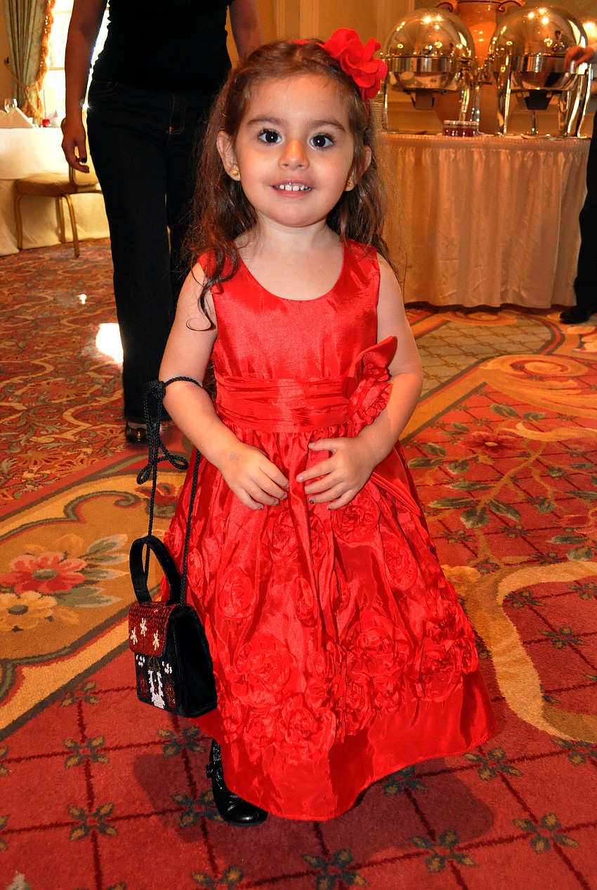 Valentina Cola, 3, wore a fancy, red dress, matching headband and carried a holiday purse at the Breakfast with Santa at the Ritz Carlton.