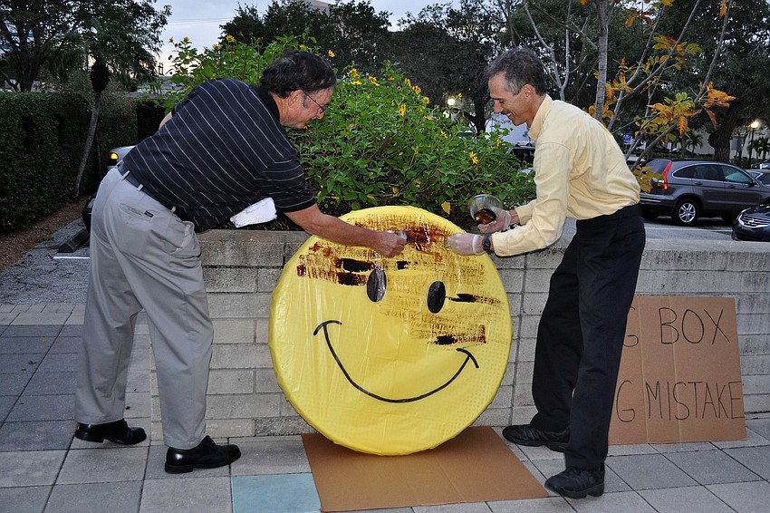 Mike McClue and Joe Paparatto tar and feather the smiley face.
