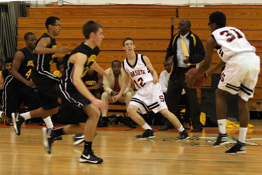 Sarasota High Schoolâ€™s Shaqvese Johnson, No. 31, attempts to pass the ball to teammate Blake Haga, No. 12.
