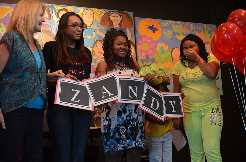 Zandy Sanders is overwhelmed with emotions as she joins her family and friends on the stage. (left to right) Councilor Myra McPherson, Girl of the Year 2012 Shayla Brown, Shakeyla Dozier, Shaiya Dozier and Zandy Sanders