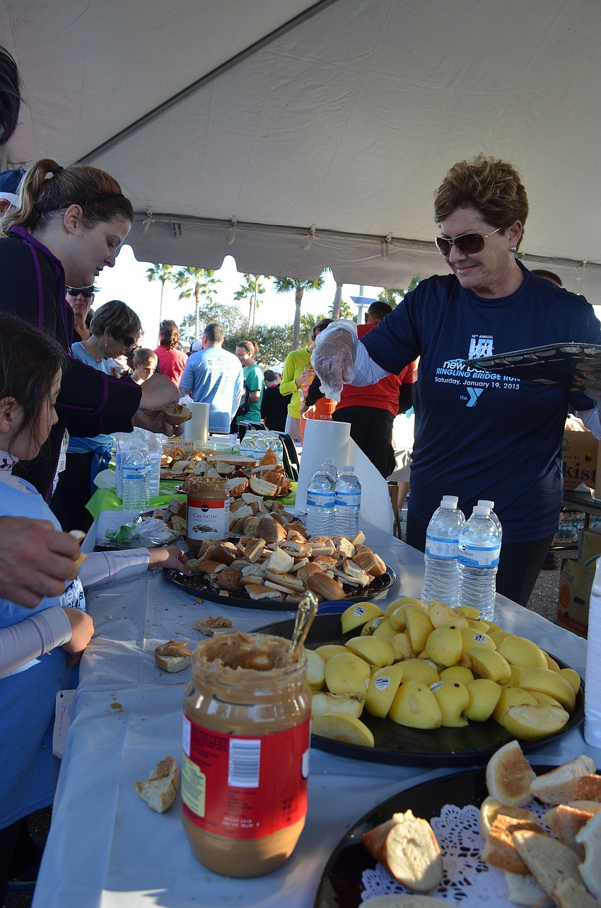 Volunteer Cathy Pritchard passes out snacks to runners after the race.
