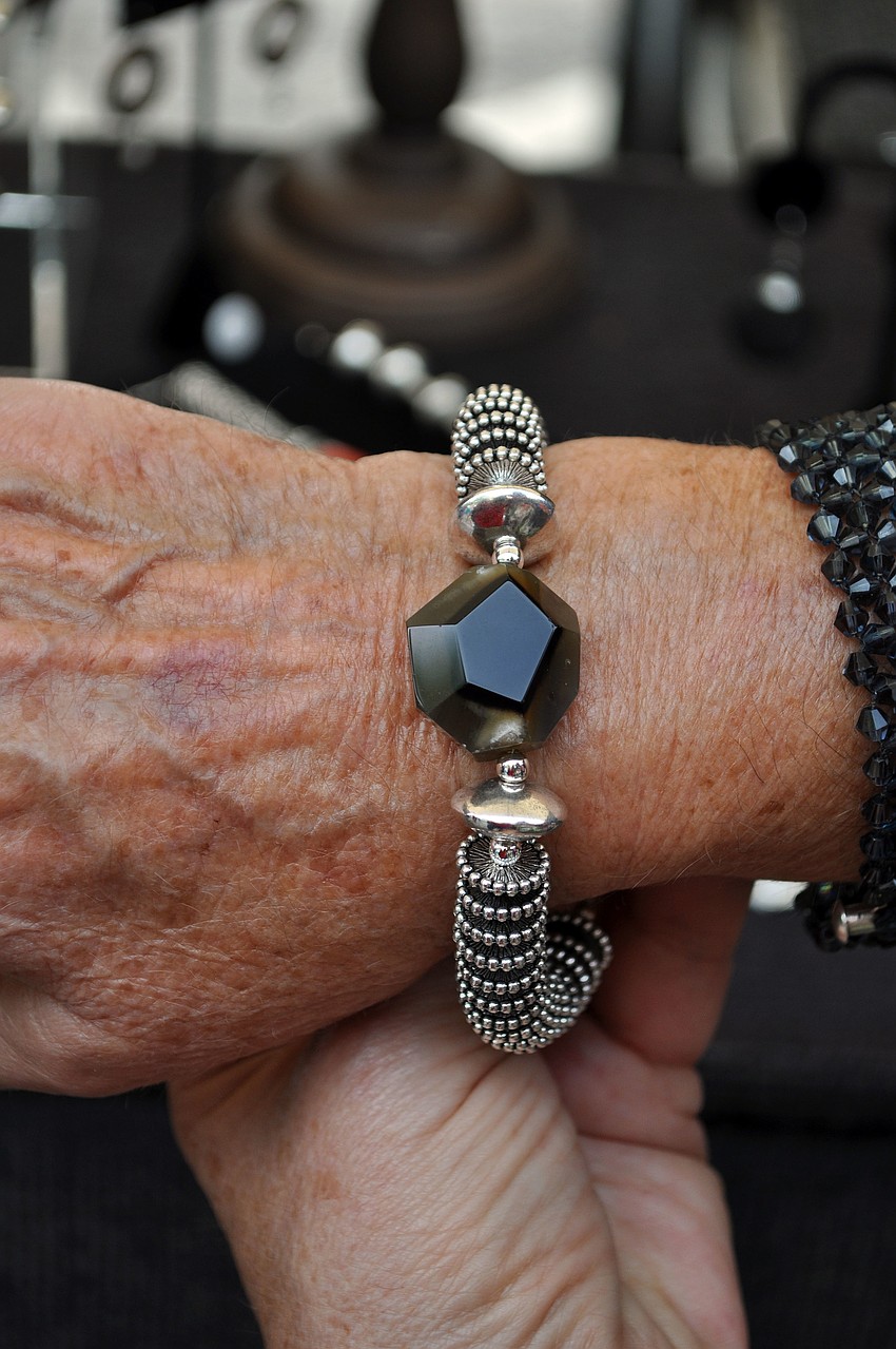 Leanne Boris tries on a bracelet made by Michael Dandren that features a large piece of agate.