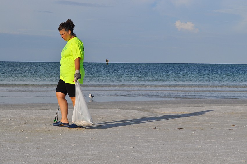 Siesta Key Association member Maria Shay scouts the shoreline for refuse.