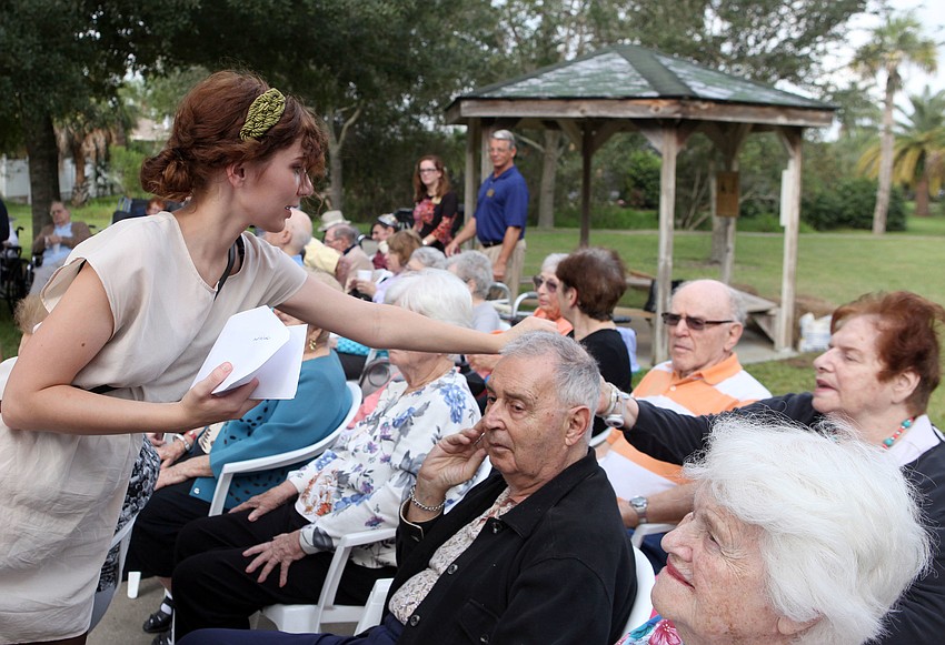 Sarah Dietz hands out pieces of paper with sins on them.