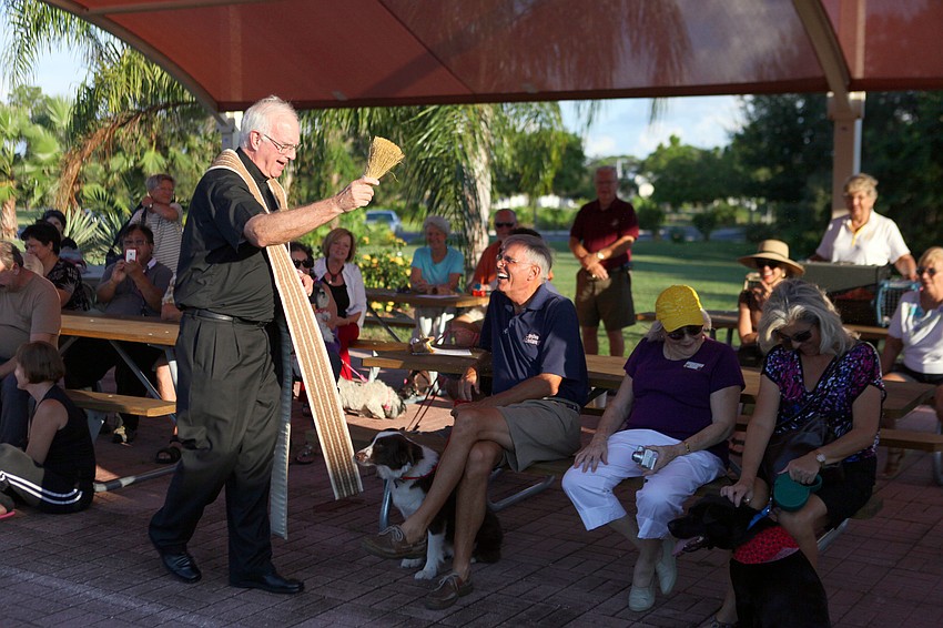 Father Fred Tillotson sprays the crowd with holy water Friday, Sept. 28 at Our Lady of Mount Carmel in Osprey.