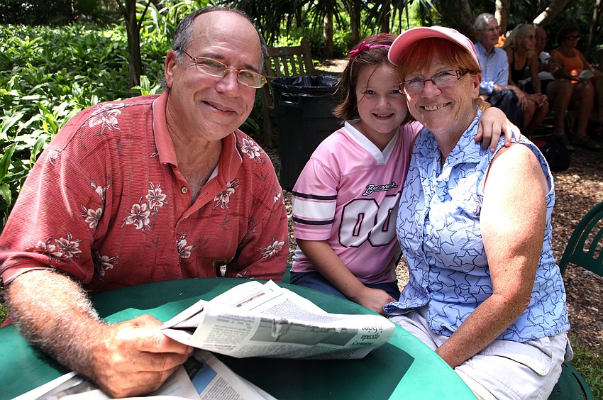 Manuel Lopez poses with Alex Herman, 8, and her grandmother, Chris Hanrahan