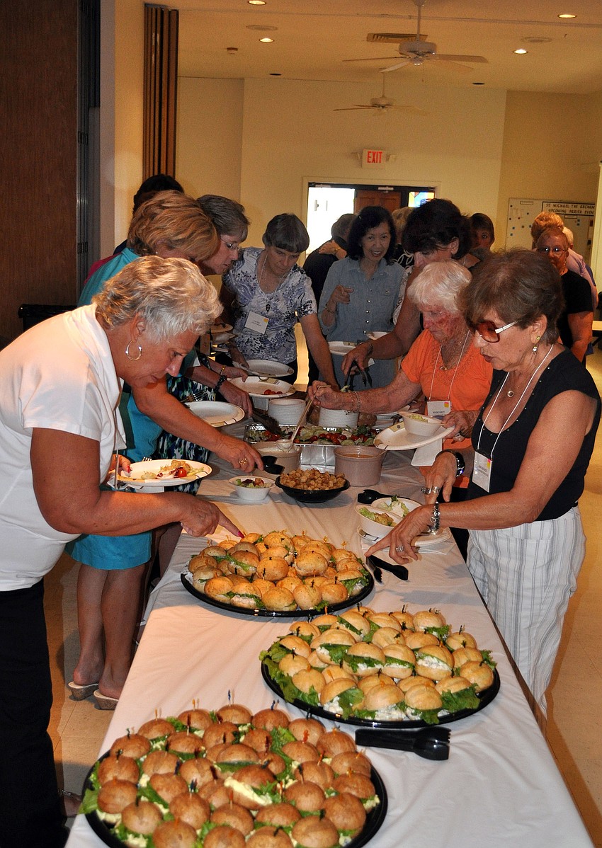 The women of St. Michael the Archangelâ€™s Womenâ€™s Guild line up to get some lunch provided by Walker Catering.