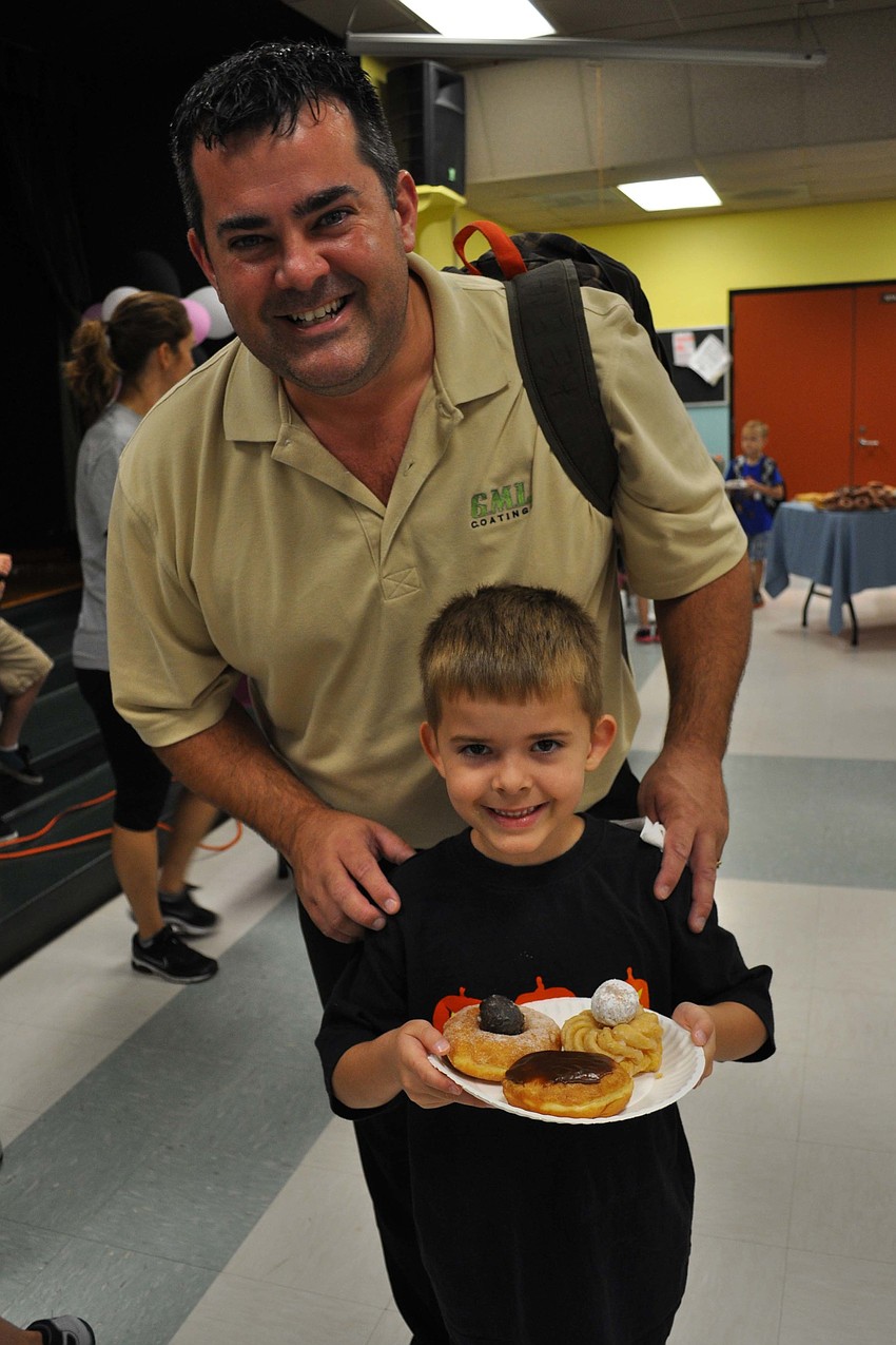 Keenan McRoberts, 5, made a face with his doughnuts. He is pictured with his father, Eric.