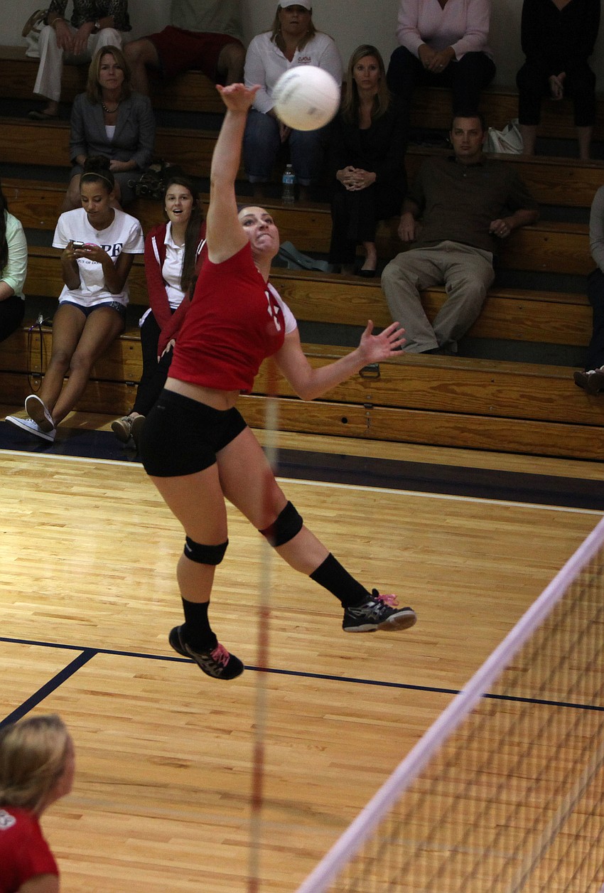 Sarah Soscia, No. 15, jumps up and spikes the ball over the net to the Out-of-Door Academy players Tuesday, Oct. 23, during the semifinal match between Cardinal Mooney High School and the Out-of-Door Academy.