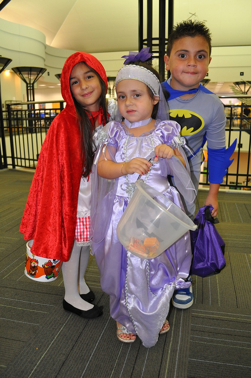 Amanda Rodriguez, 6, Brianna Gonzalez, 3, and Brian Gonzalez, 7, have fun trick-or-treating around the library.