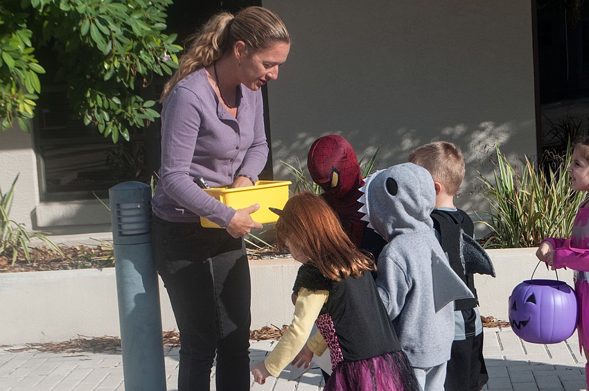 Preschool director Sarah Schebel hands out treats to children.