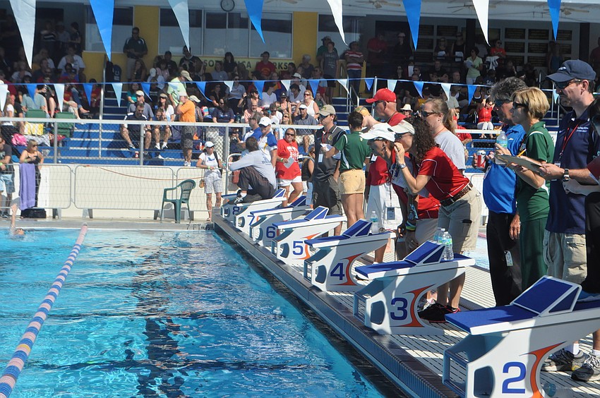 Coaches time swimmers as they race through the lanes.
