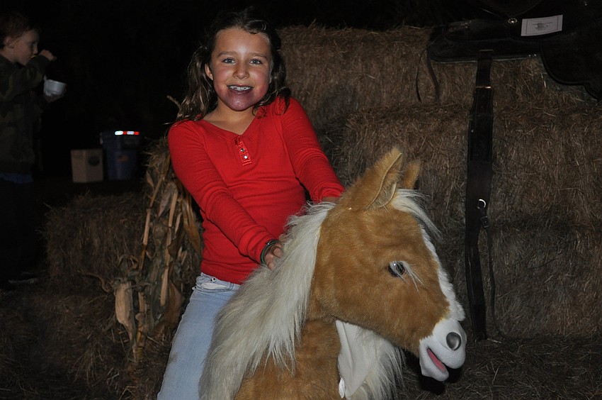 Carmella Romeo rode a stuffed horse.
