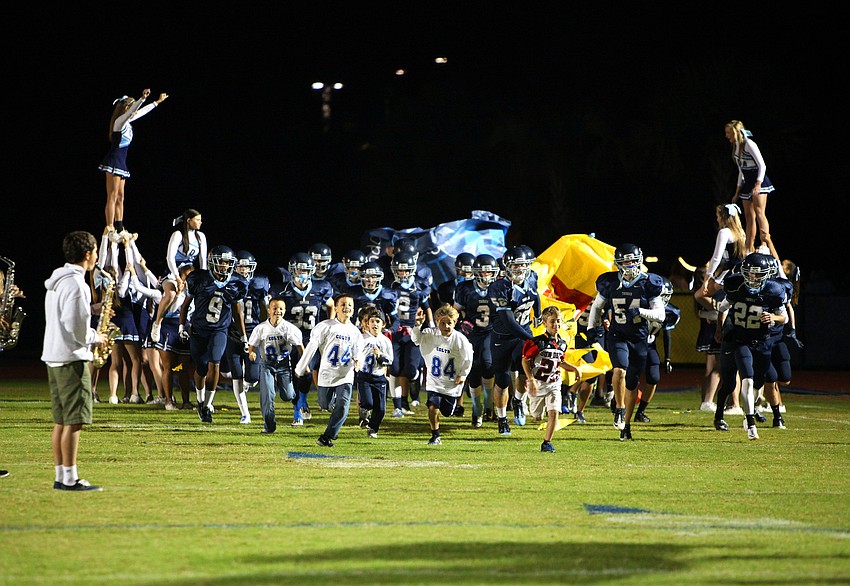 The Out-of-Door Academy runs out onto their home field Friday, Nov. 9, during the Cardinal Mooney versus The Out-of-Door Academy game at Thunder Stadium.