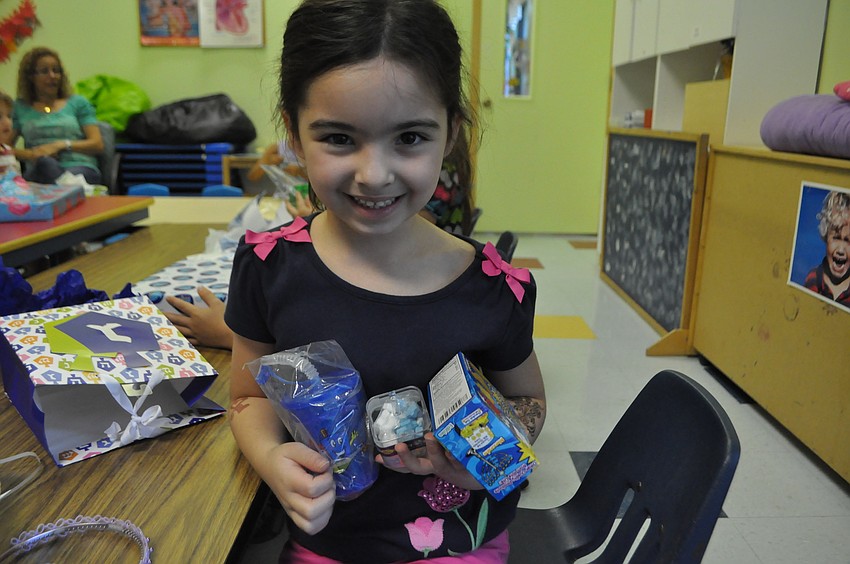 Mia Laporta shows off the gifts she got from the Hanukah gift exchange.