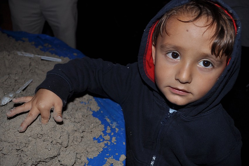 Luca Schlosberg, 3, practiced his sand menorah-making skills.