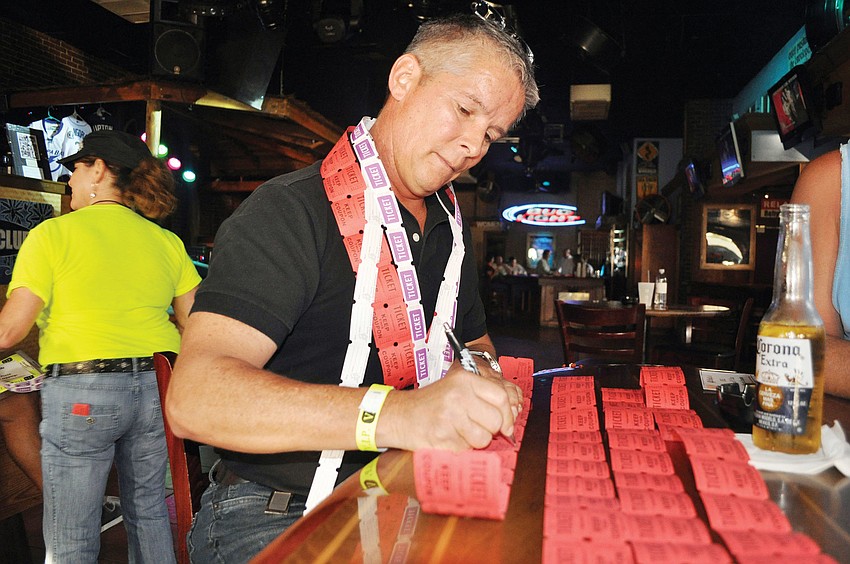 Bill Borgelt fills out his raffle tickets for the Cure Cara Fundraiser, Oct. 4, at Beach Club.