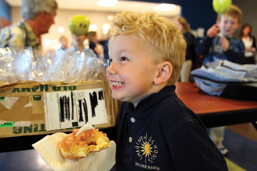 Blake Chamberlain, 5, gave his dad a sugary smile while enjoying a donut during Imagine Schoolâ€™s Donuts with Dad breakfast.