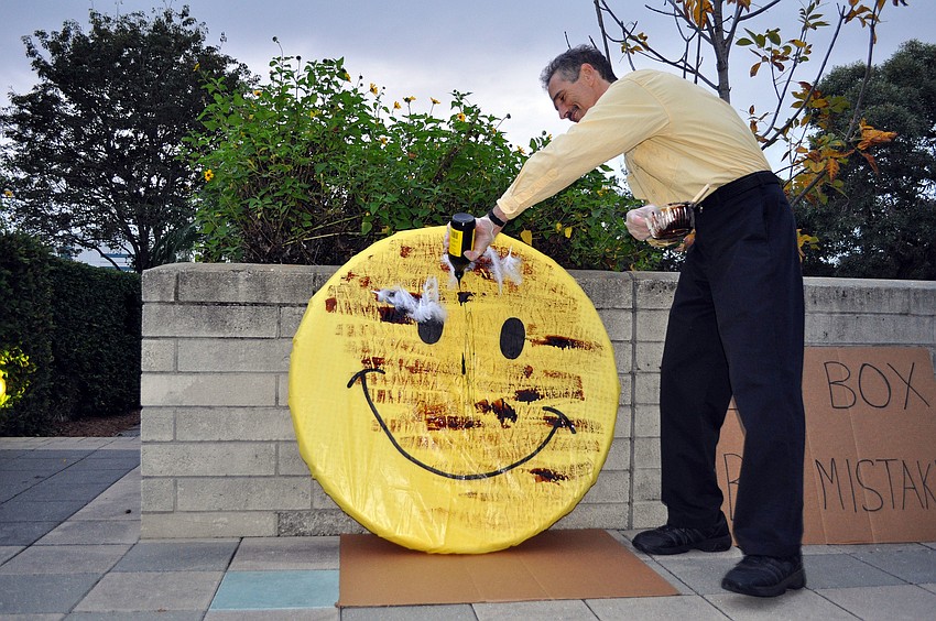 Joe Paparatto pours on more molasses onto the smiley face.
