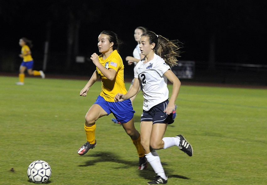 Sarasota Military Academyâ€™s Mia Venafro and The Out-of-Door Academyâ€™s Kimmy Comito charge toward the ball.