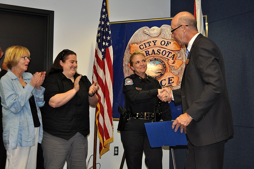 Bernadette DiPino shakes hands with City Manager Tom Barwin after being officially sworn in as Sarasota's police chief Friday, Jan. 18, at the Police Department.