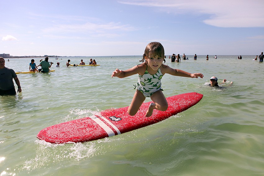 Brooke Decillis, 5, jumps off a surfboard and into the water Saturday, Sept. 15.