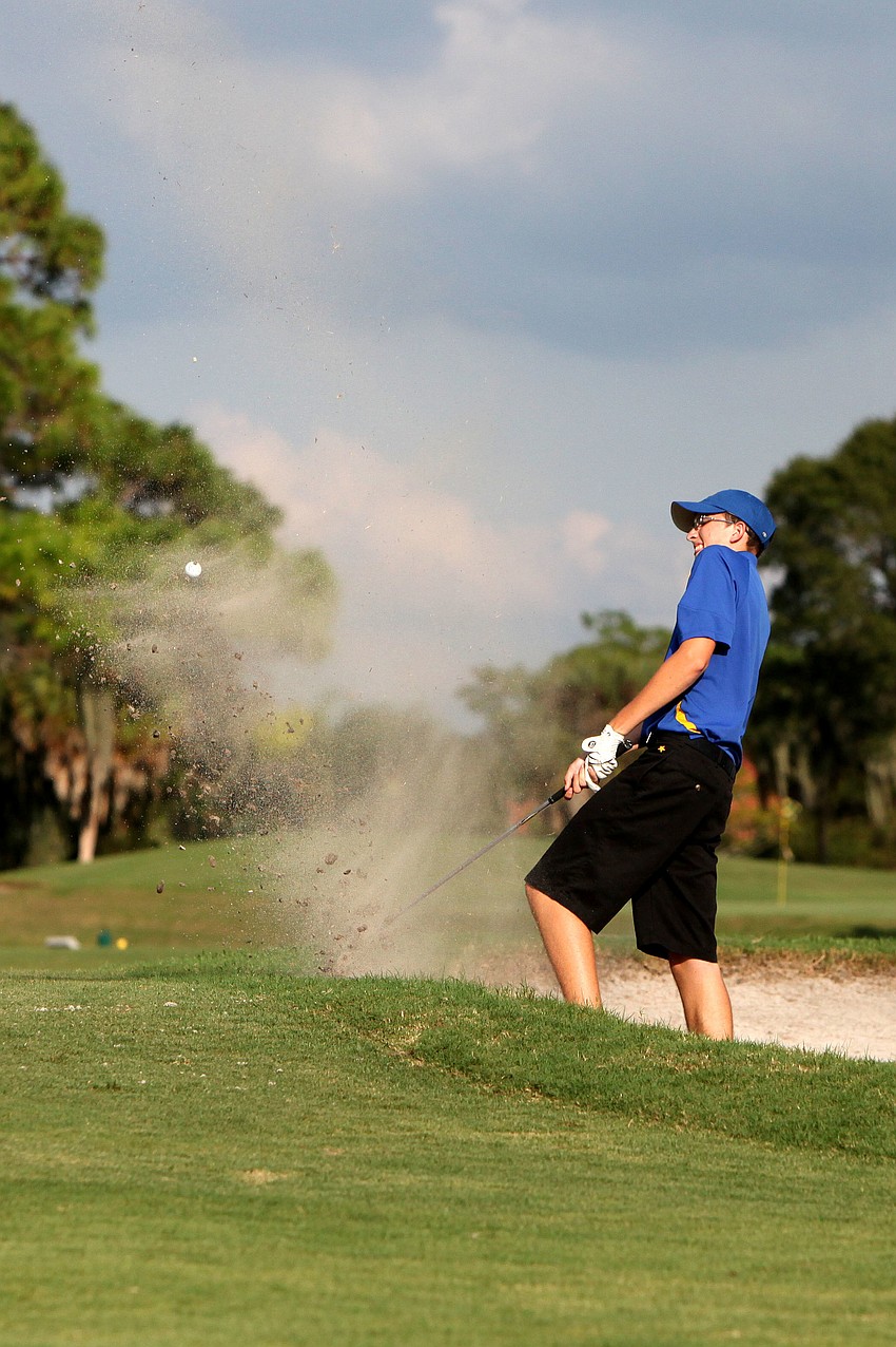 Stephen Waskom, 16, leans back as sand flies up into the air after hitting his ball out of a sand trap Tuesday, Oct. 9.