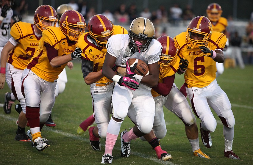 Tony Jones, No. 3, get tackled by a grouping of Cardinal Mooney cougars Friday, Oct. 12, at Cardinal Mooney.