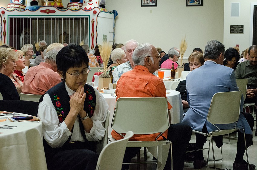 Parish members say a prayer before dinner.
