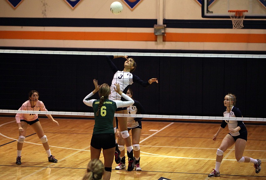 Gabriella Costa, No. 3, gets some air as she jumps up to spike the ball at Lauren Biach, No. 6.
