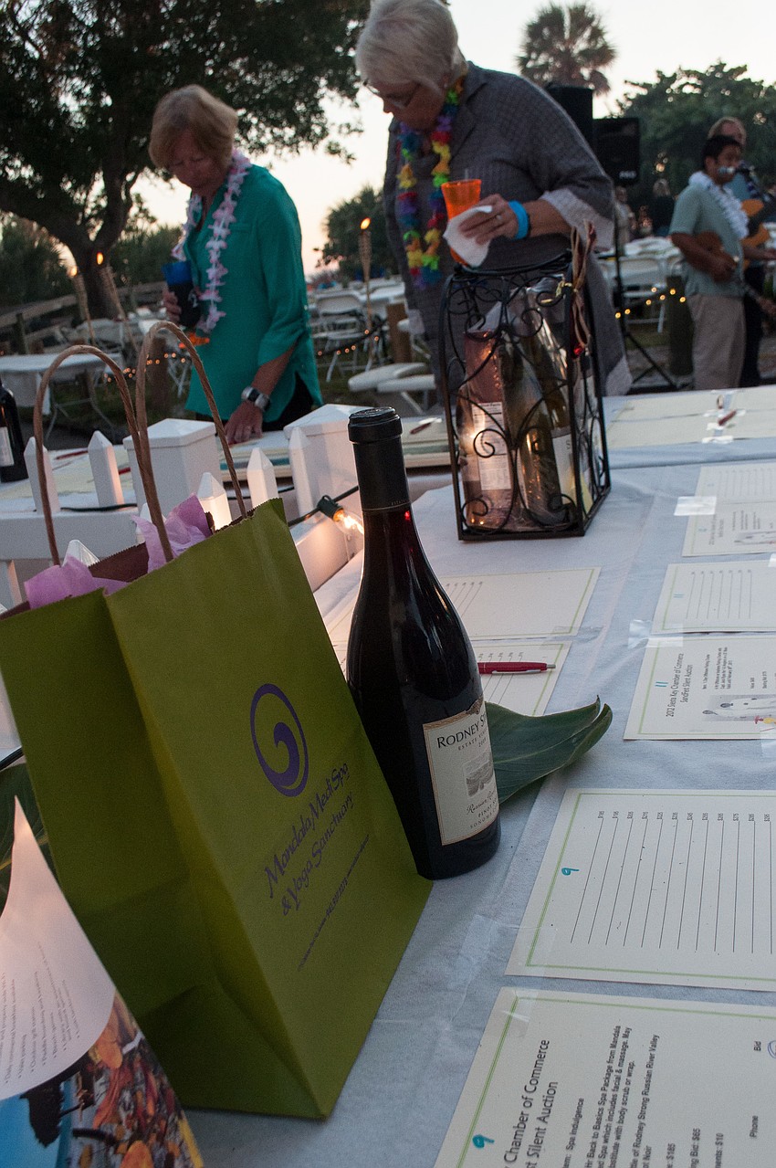 Partygoers bid on donated silent auction items.