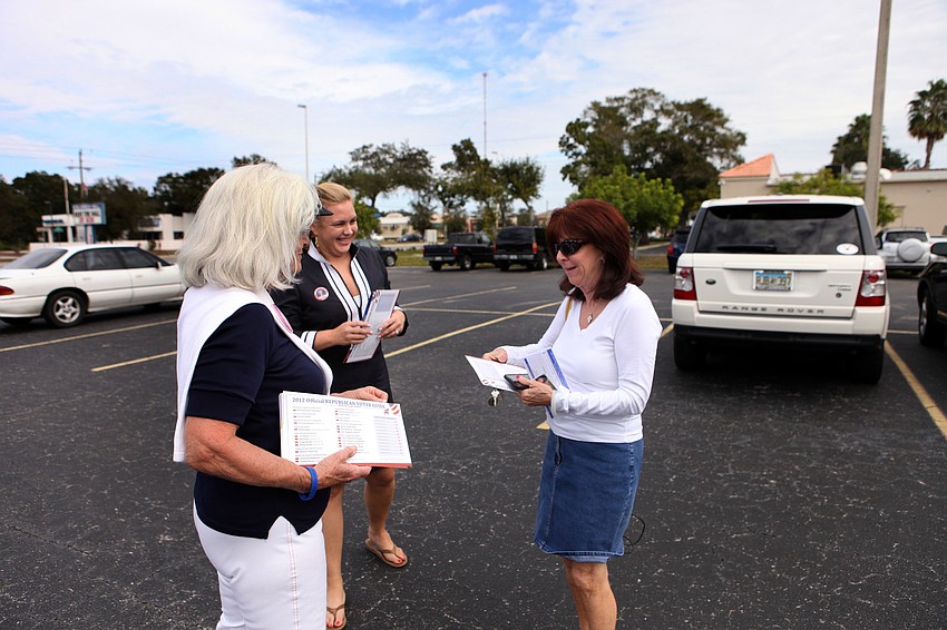 Graci McGillicudy and Mackenzie Mudgett gives Peg Schmitt some extra information on the Republican party before Schmitt headed in to vote.