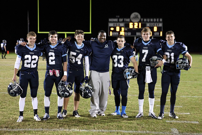Coach Timmons, center, poses with the Out-of-Door Academy seniors prior to the game.