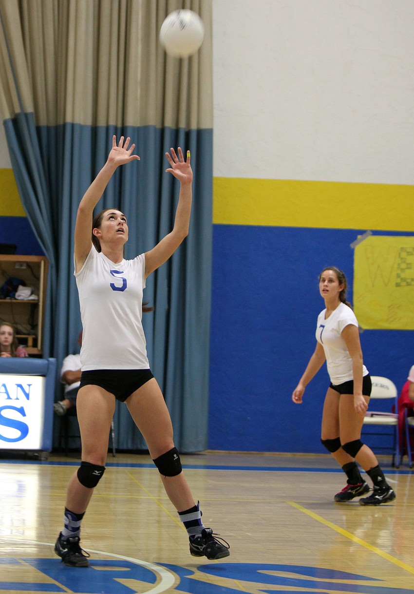 Amanda King, No. 5, sets the ball up for her teammates to hit over the net.