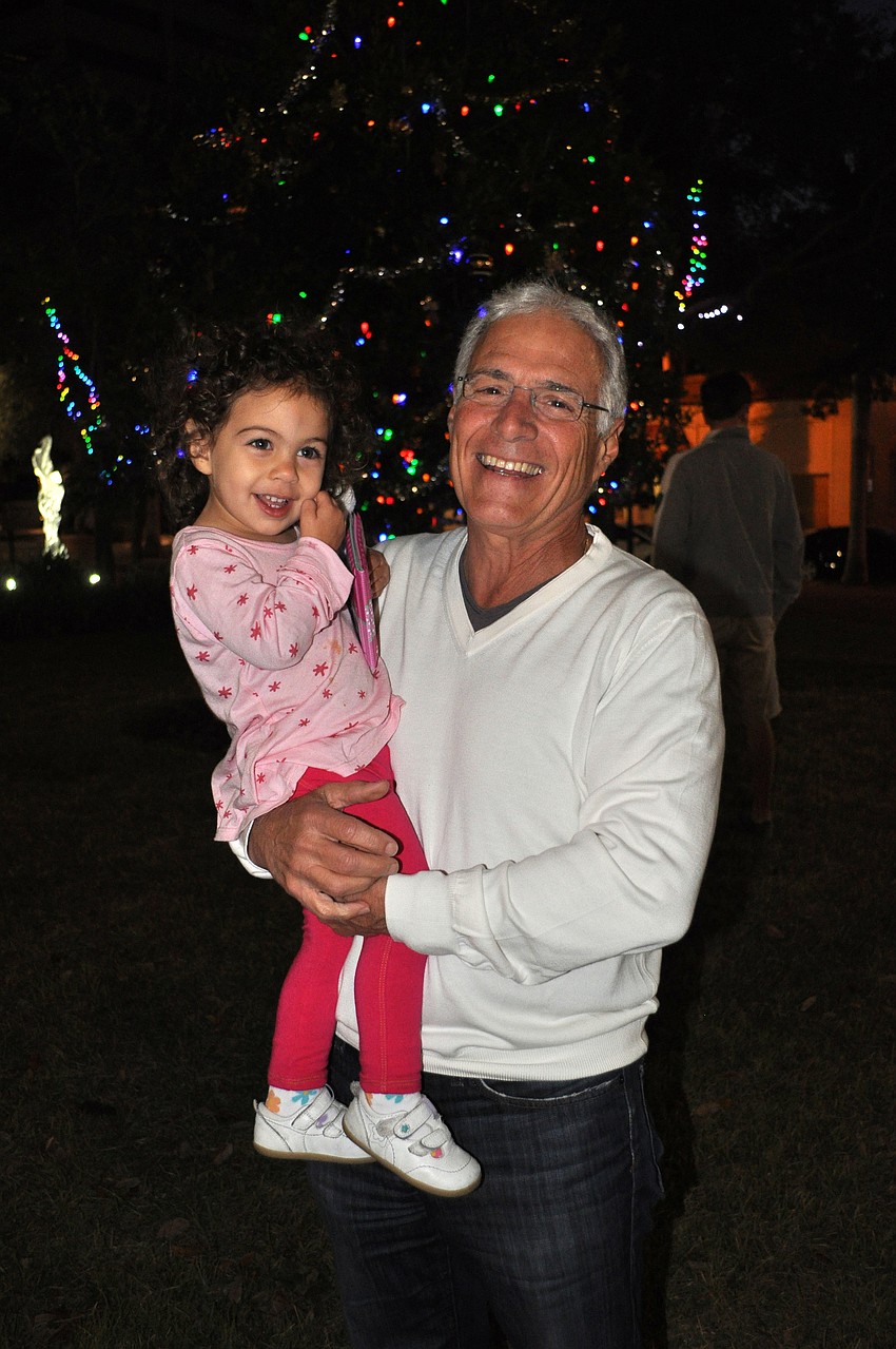 Maia Linehan-Failla, 2, with her grandfather, Joe Failla at the Christmas tree lighting Friday, Nov. 23, at Five Points Park.