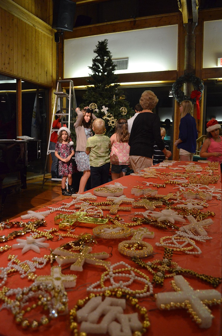 Children decorated the Christmas tree with an assortment of ornaments.
