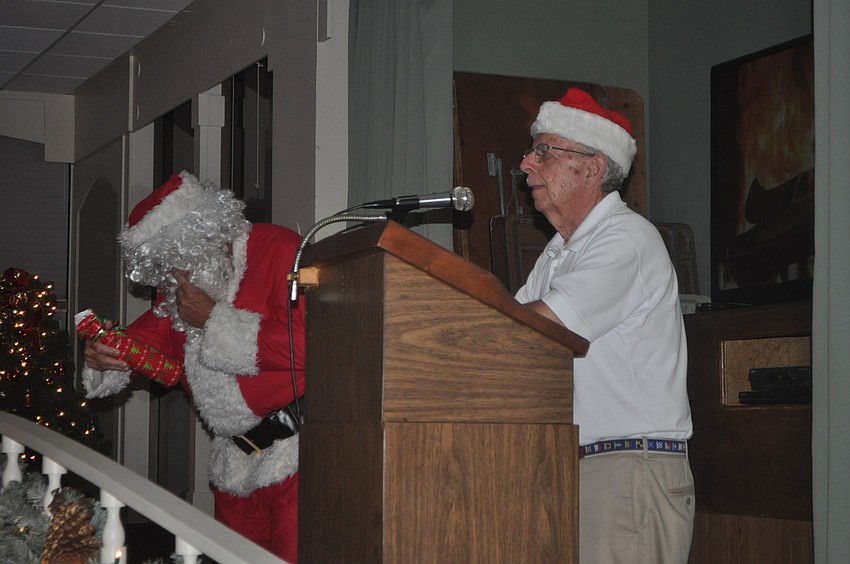 Dock Master Bob Geracie with help from Santa, also known as John Troup, passed out gifts (bottles of wine) to members who decorated a dock.