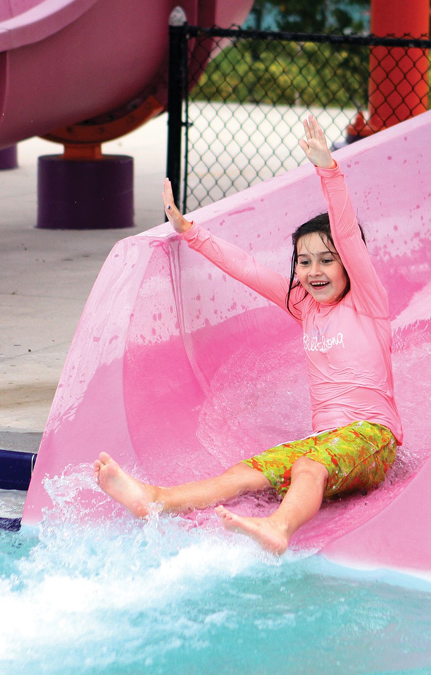 Erica Daphin, 7, raised her arms up in the air as she made er way down the waterslide at Sarasota YMCAâ€™s Healthy Kids Day.