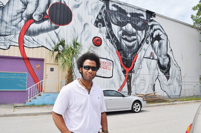 Kenneth Blake poses in front of the MTO mural that was painted on the side of Sarasota Architectural Salvage.