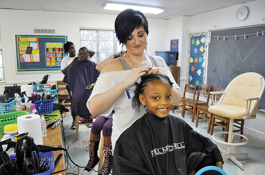 Cherie Diaz braids Markeyl Greenâ€™s at Church of the Redeemer as part of the Hope Kids Community Day of Hope.