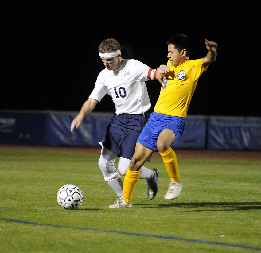 The Out-of-Door Academy senior captain Sean Kirshe attempts to fight off Sarasota Military Academy senior captain Leonardo Cisneros.