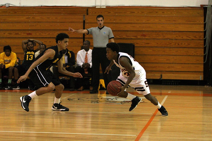 Booker High Schoolâ€™s Andre Johnson, No. 5, tries to stop Sarasota High Schoolâ€™s Dakota Cotner, No. 23, from making his way up the court.