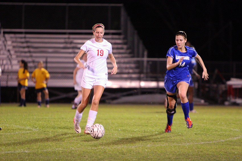 Cardinal Mooneyâ€™s Sam Savinsky, No. 19, kicks the ball up the field while keeping the ball away from Gatewayâ€™s Kelsey Anders, No. 14.