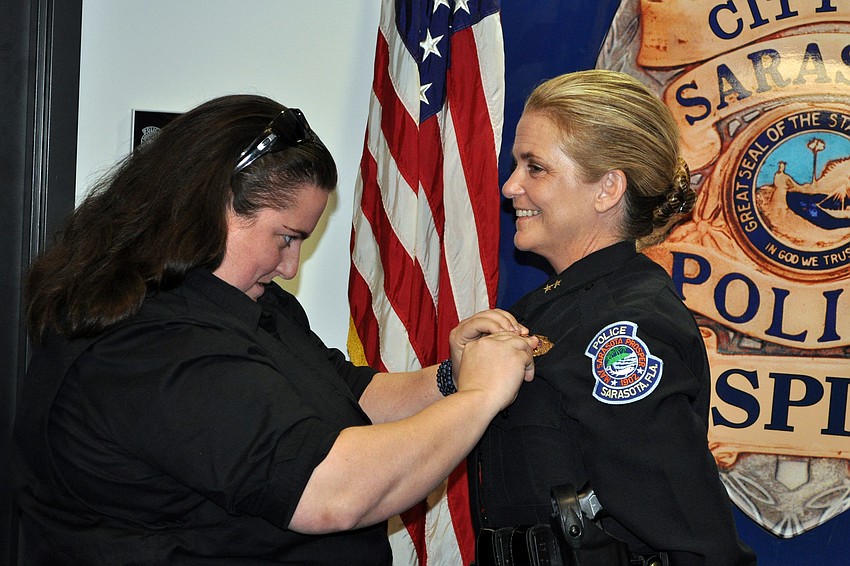 Bernadette DiPino's daughter, Tabitha Hays, a police officer in Maryland, pins DiPino during the ceremony.
